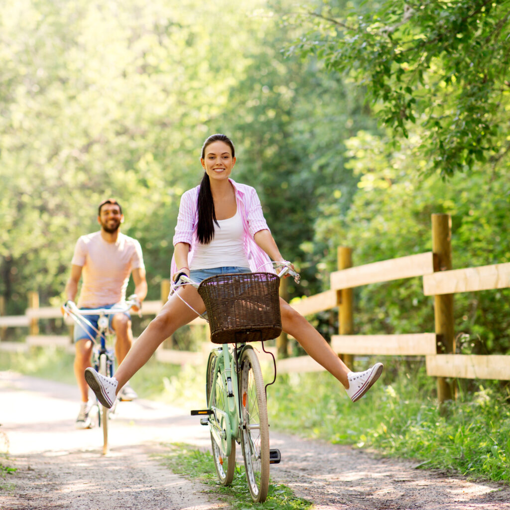 happy couple with bicycles at summer park